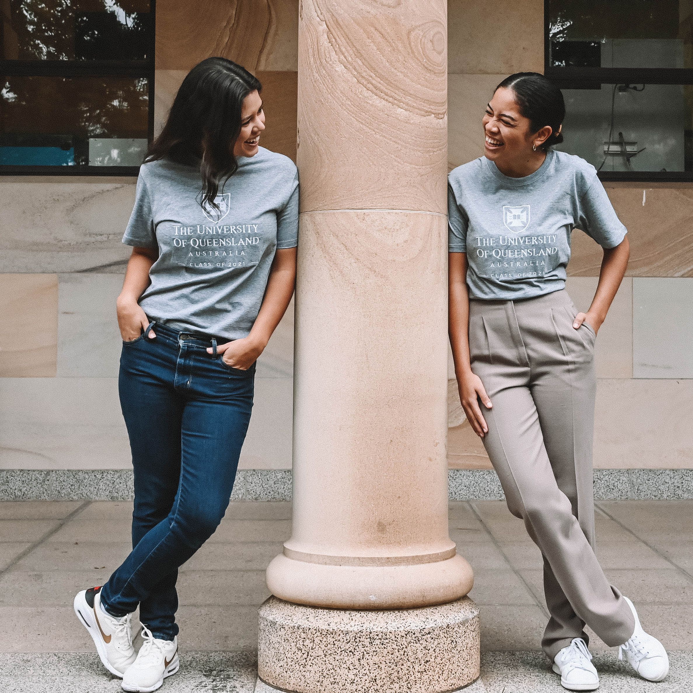 Two women laughing together and wearing UQ Shop apparel.