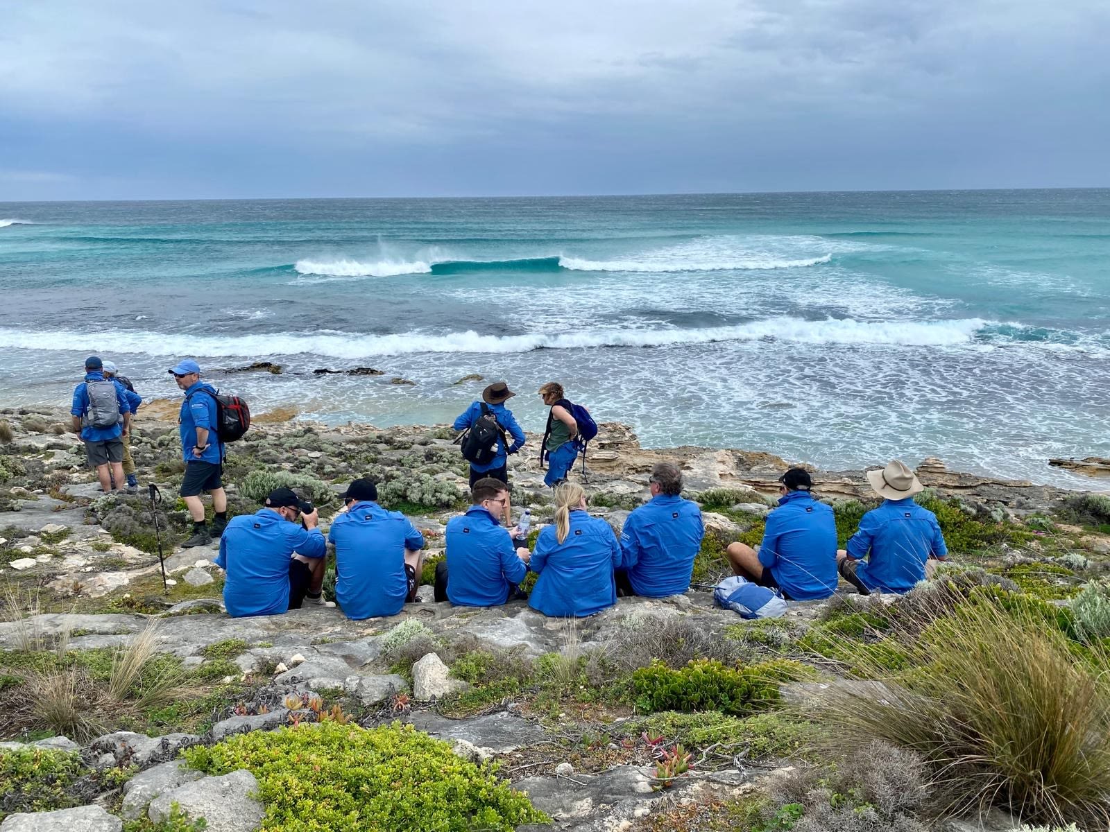Trekkers taking a break on the Kangaroo Island Wilderness Trail with the ocean in the background.