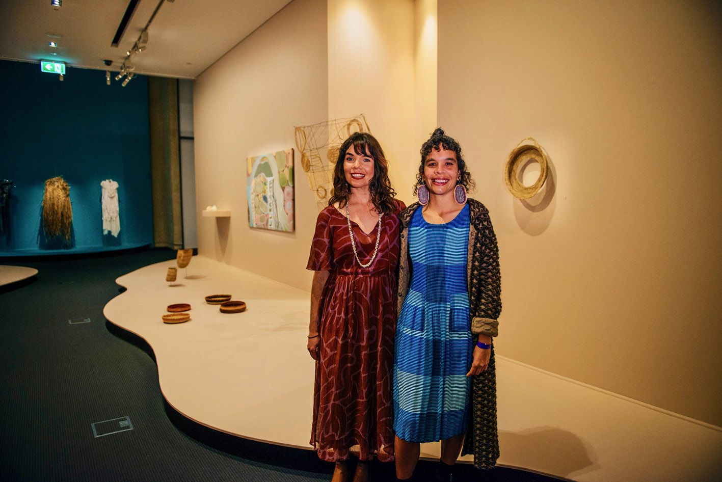 Curator Freja Carmichael with her sister and featured artist Elisa Carmichael standing in the Weaving the Way exhibition space.