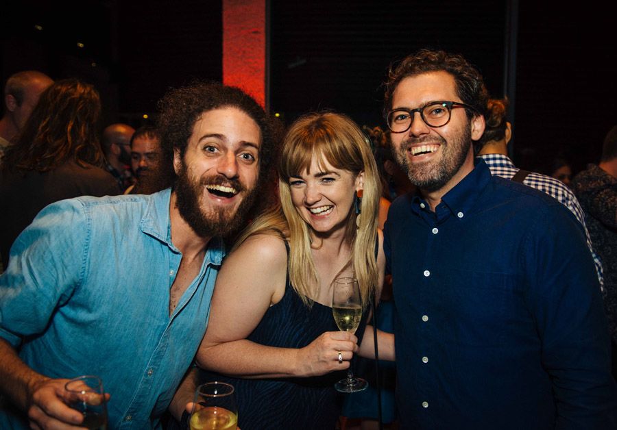 A group of three visitors to the UQ Art Museum Second Sight exhibition opening smiling.