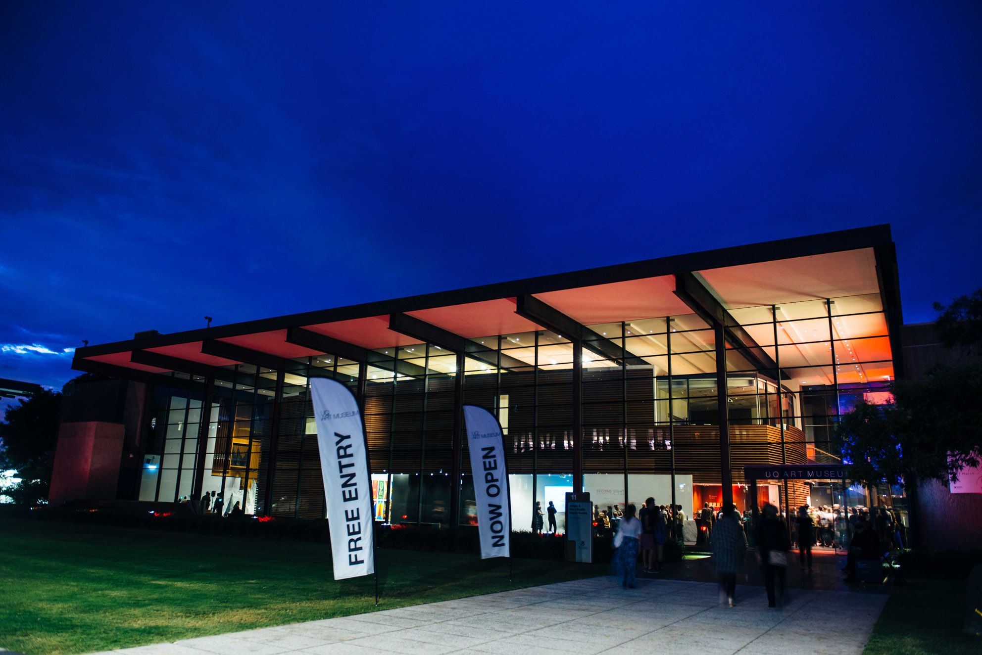 The UQ Art Museum building lit up at night for an exhibition opening.