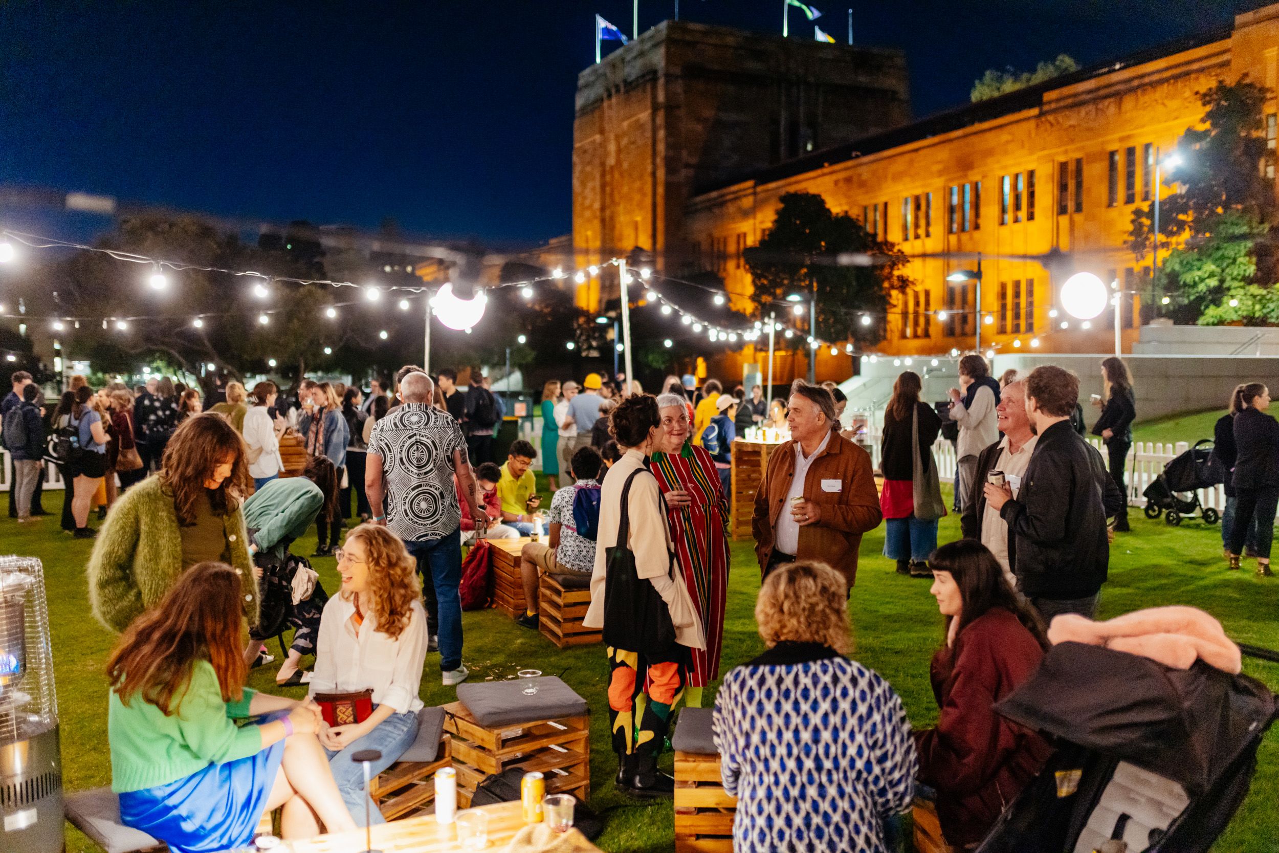 A large group of people standing outside at a night time event