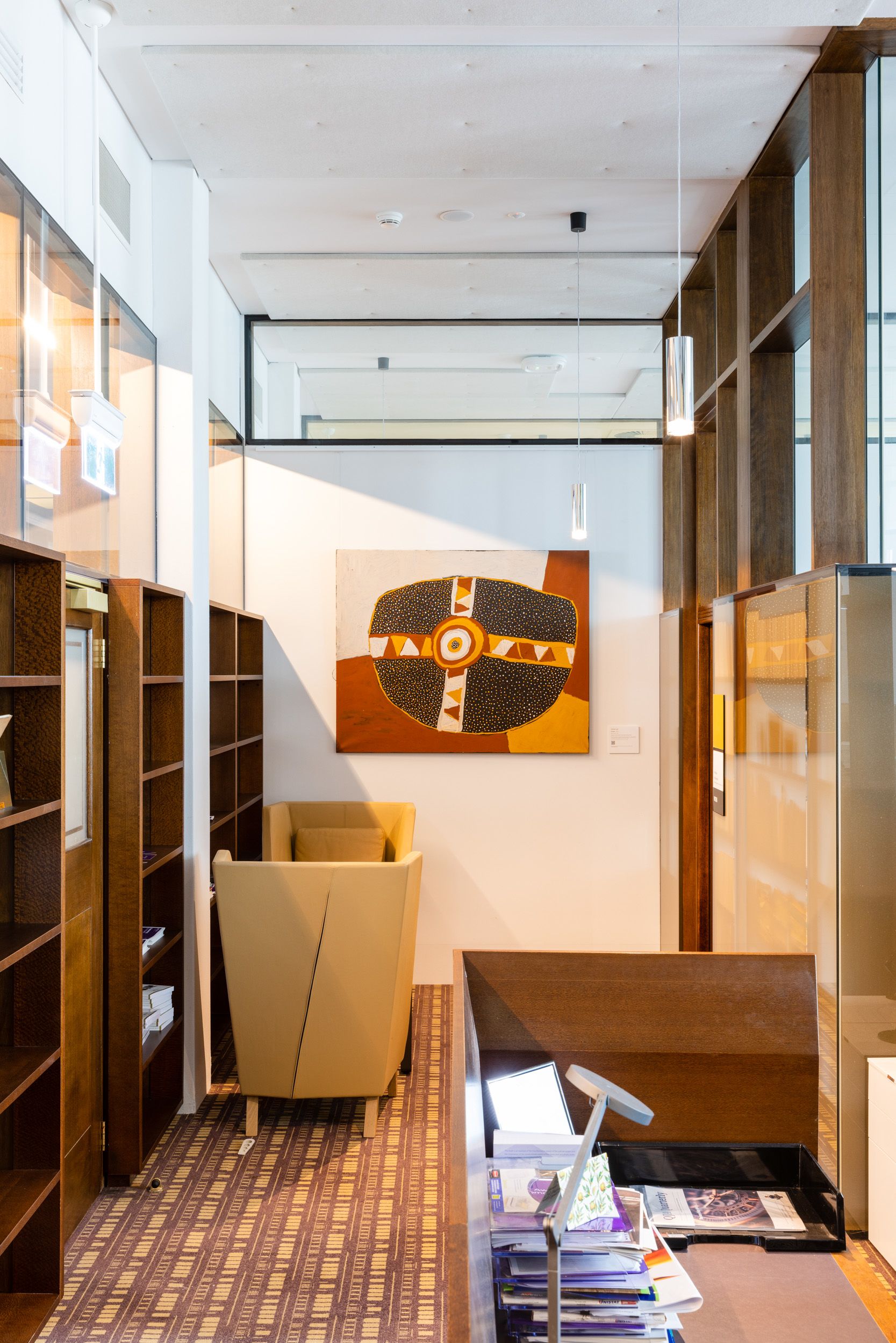 Artwork hanging on a wall between wooden shelves