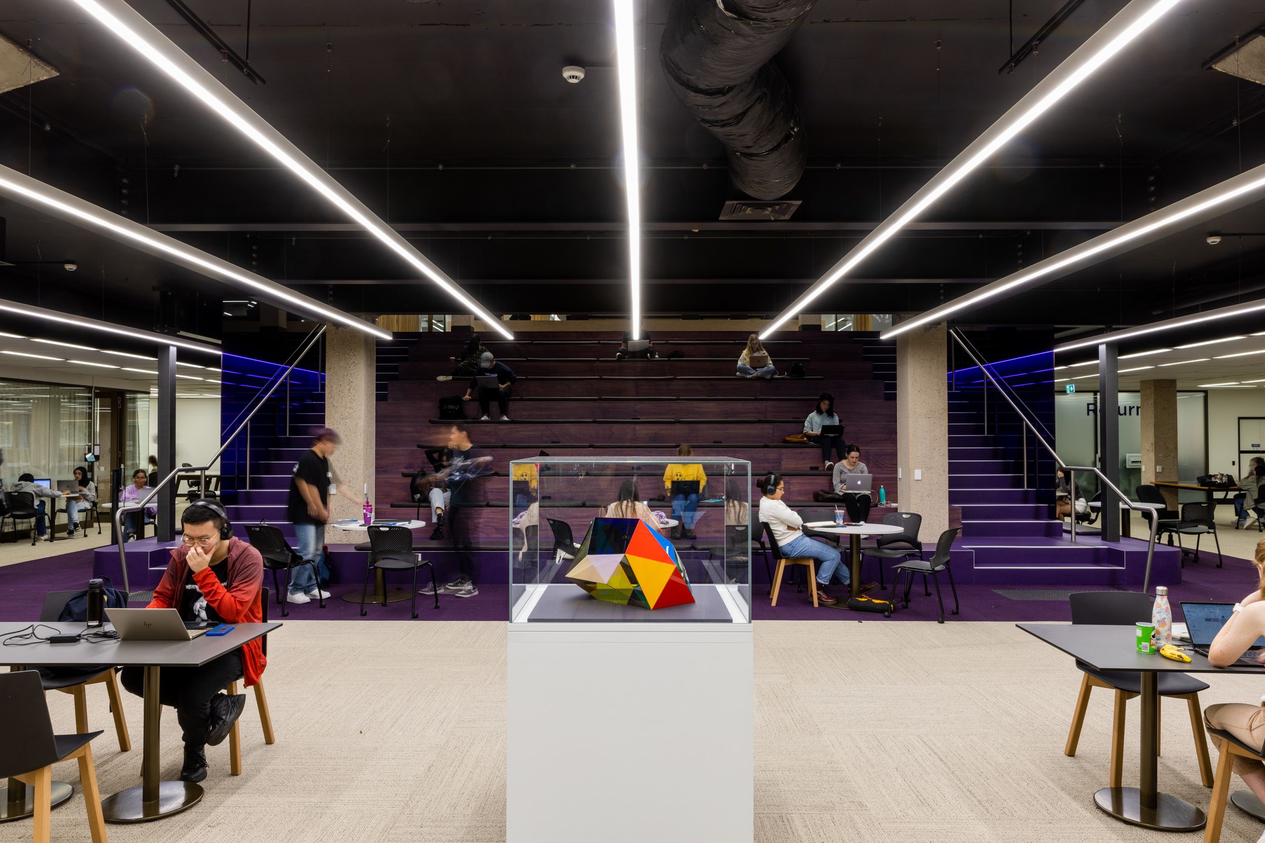 A 3d abstract sculpture inside a display case in an auditorium