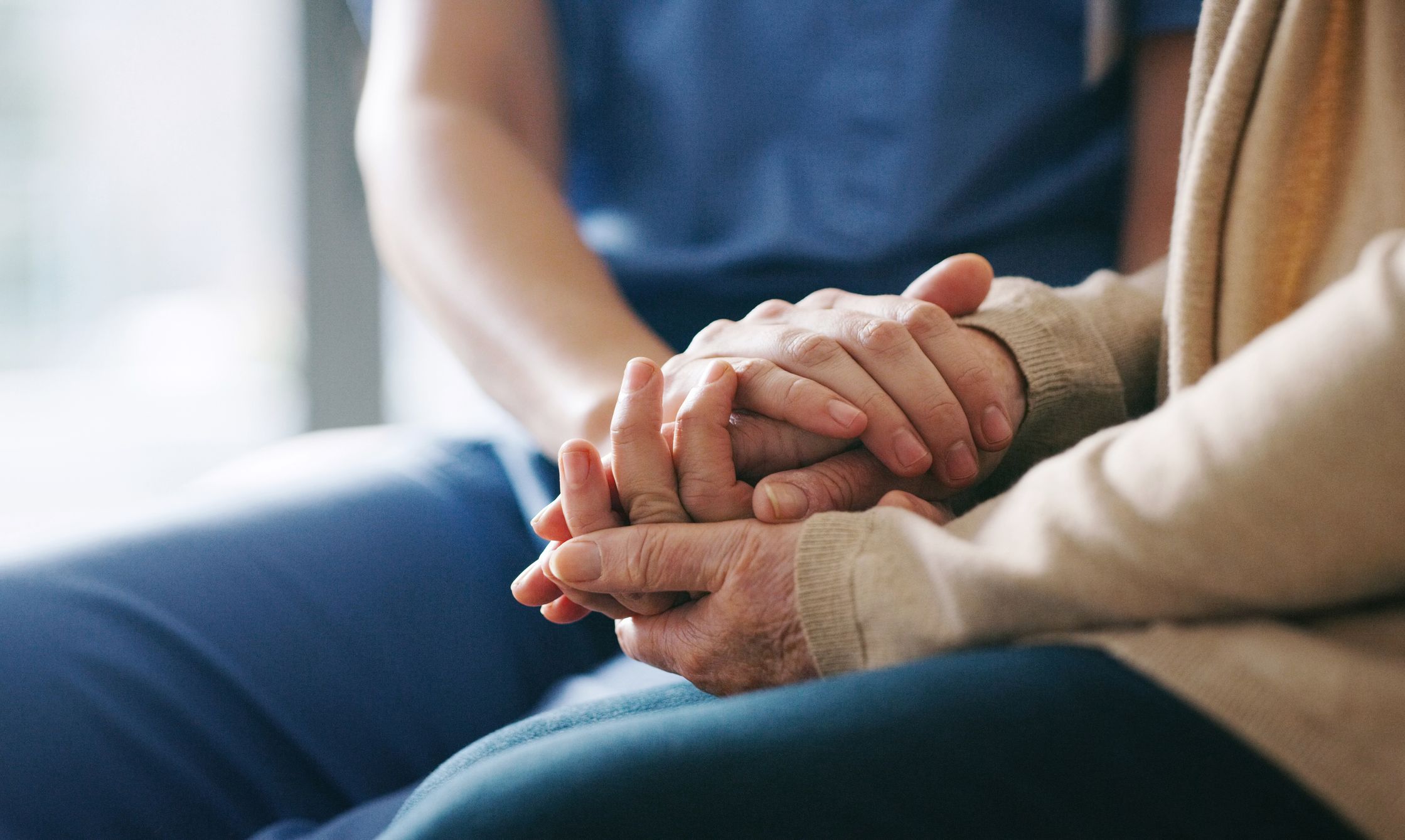 Home care worker holding hands with patient