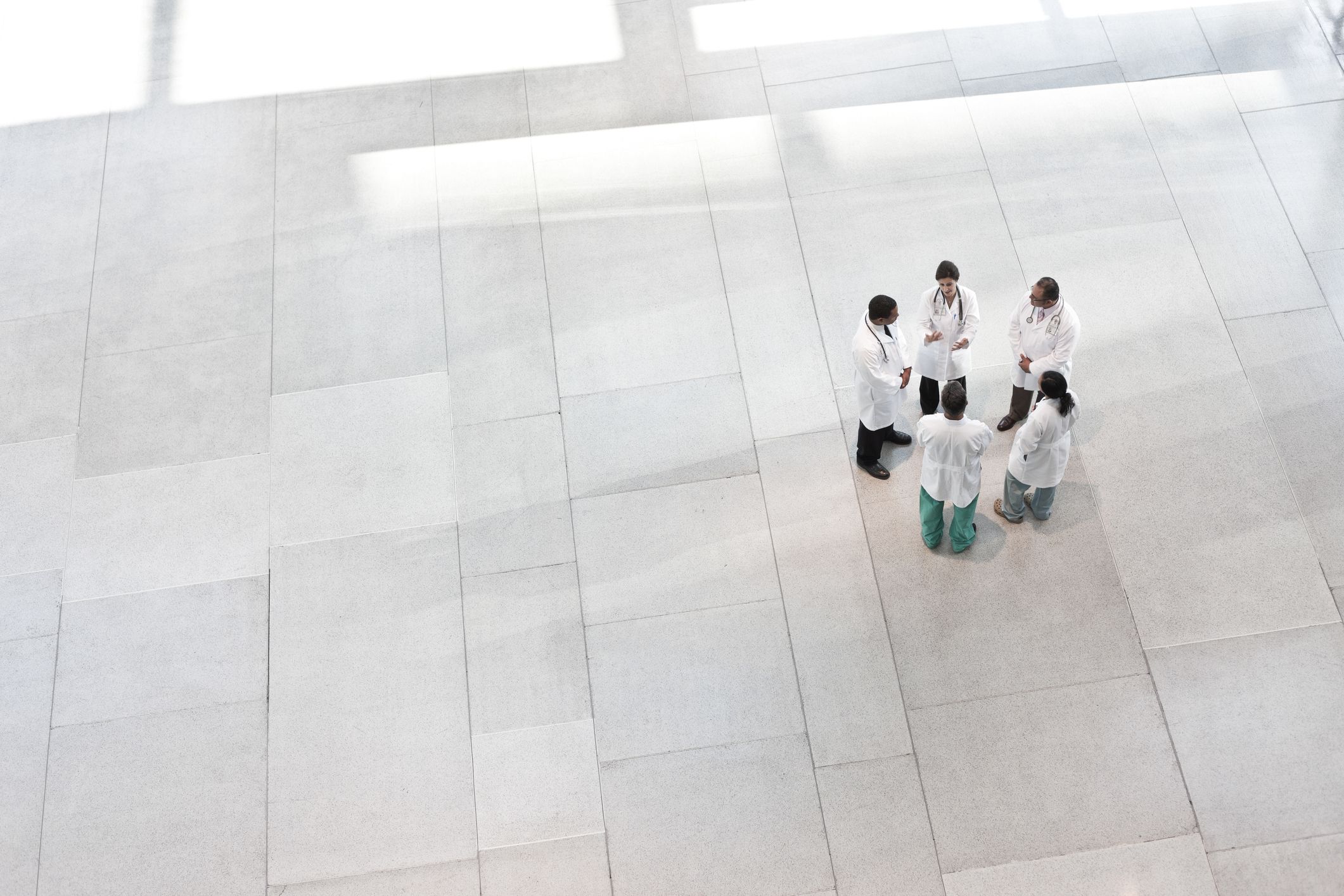 Hospital workers meeting in lobby.