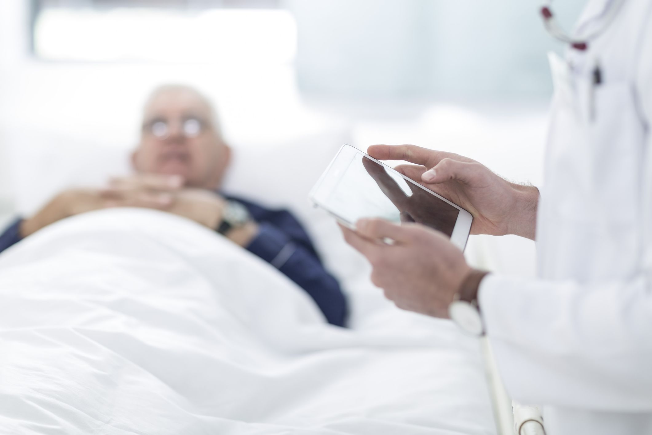 Doctor using tablet with patient.