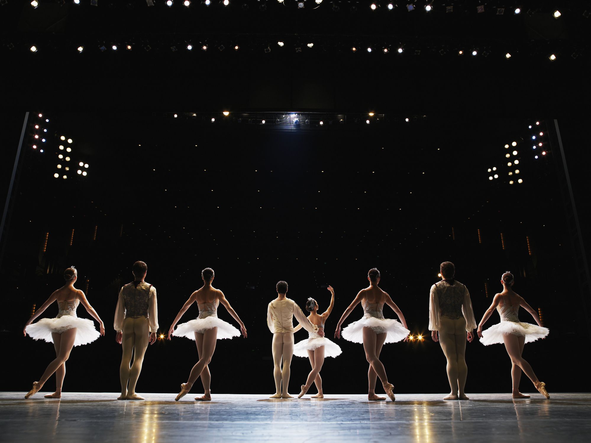 Ballet dancers on stage with crowd watching