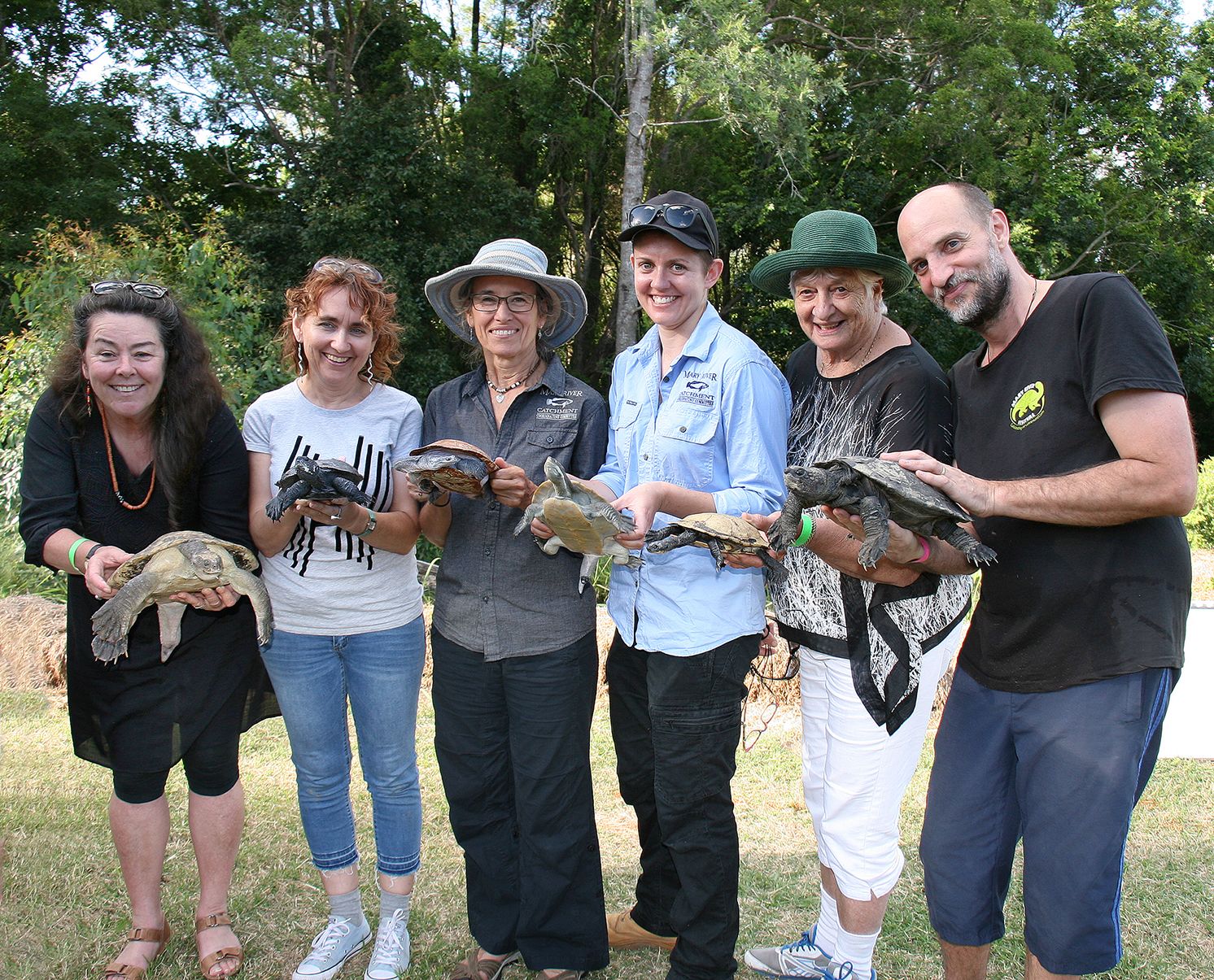 6 people, each holding a different turtle species