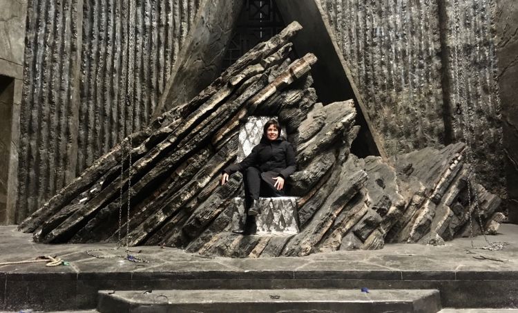 This is an image of UQ graduate Deborah Riley sitting on the Dragonstone throne during filming of season seven of Game of Thrones