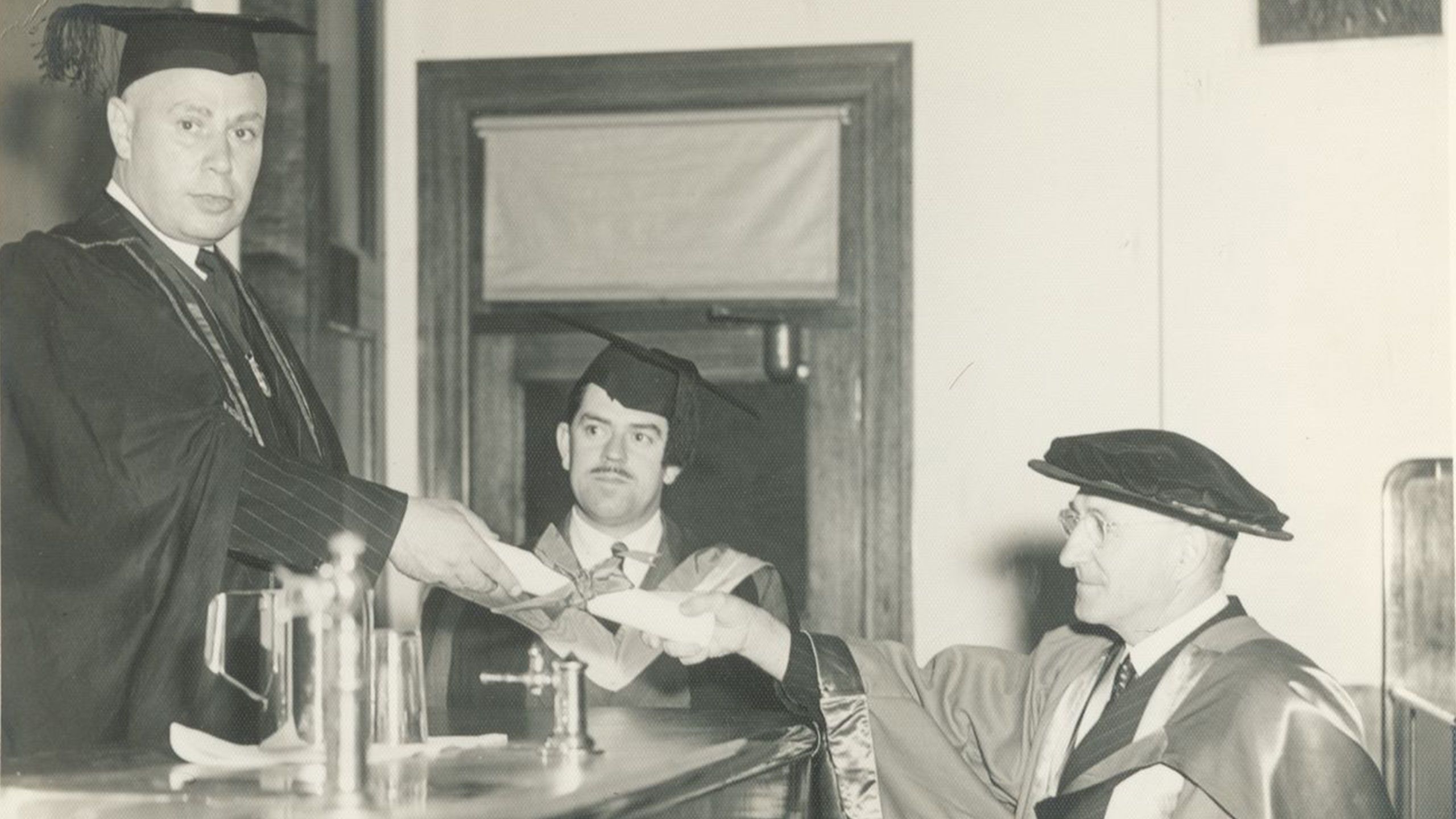 An image of Professor SF Lumb receiving his certificate admitting him as a Dental Fellow of the Royal College of Surgeons from Professor Bradlaw in 1950.