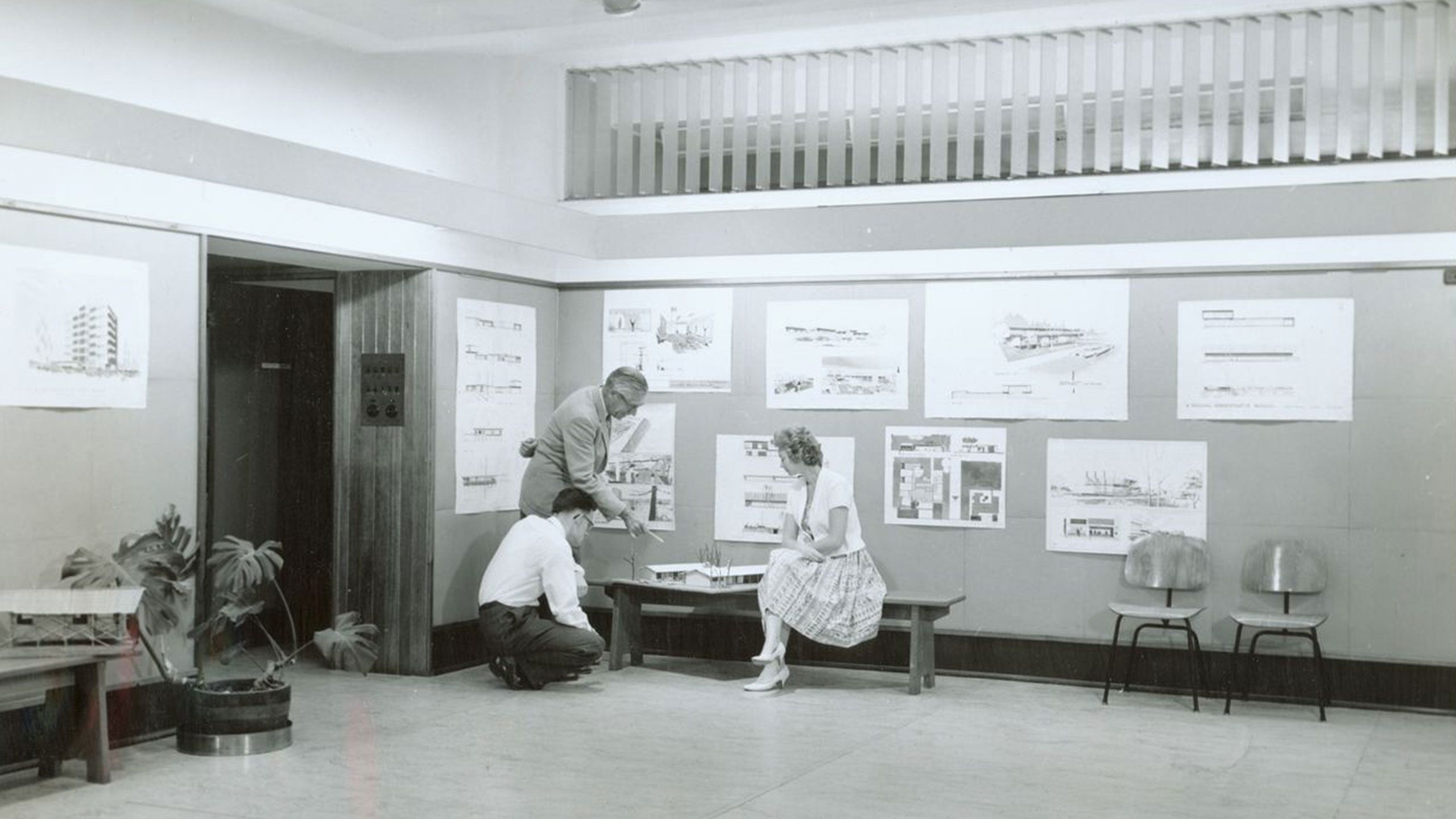 An image of people looking at a student's architectural model in UQ's Department of Architecture in 1955.