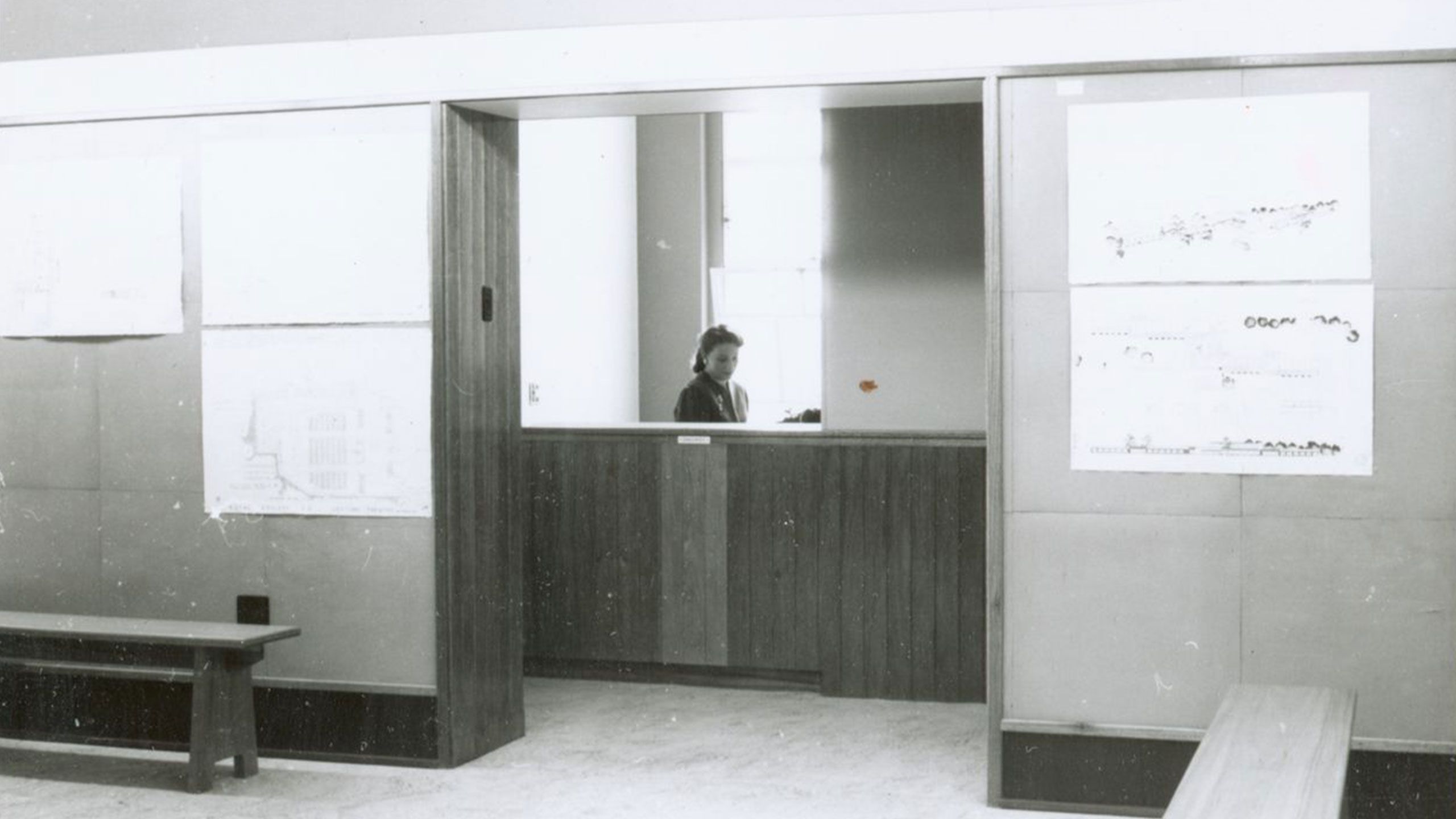 An image of a staff member at the UQ Department of Architecture enquiring counter in 1955.