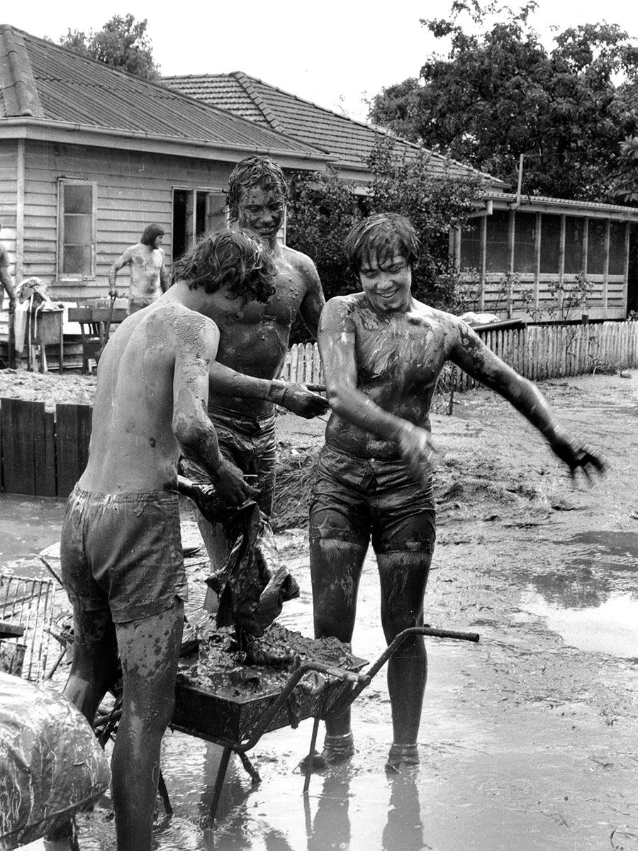 An image of students getting muddy during the 1974 floods.