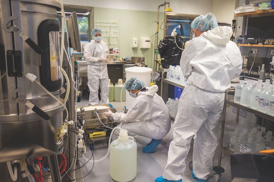 An image of researchers in personal protective gear working in the lab to develop a vaccine.