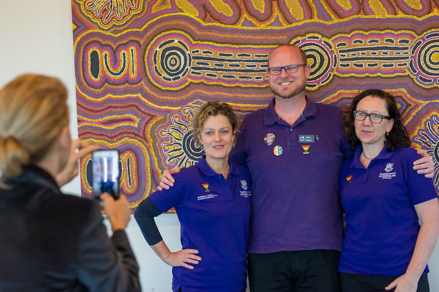 An image of three people dressed in purple being photographed by a woman in August 2017.