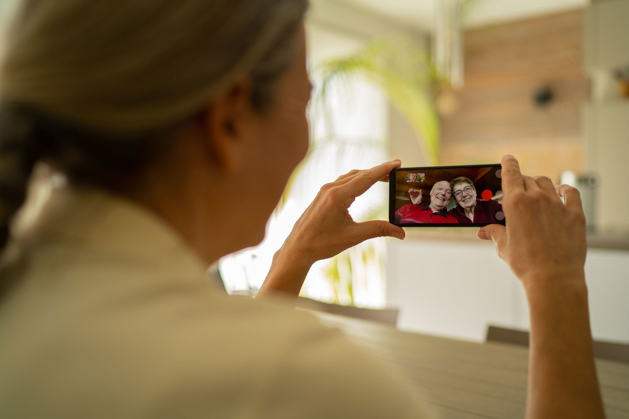 An image of a woman talking to her parents using live videoing technology.