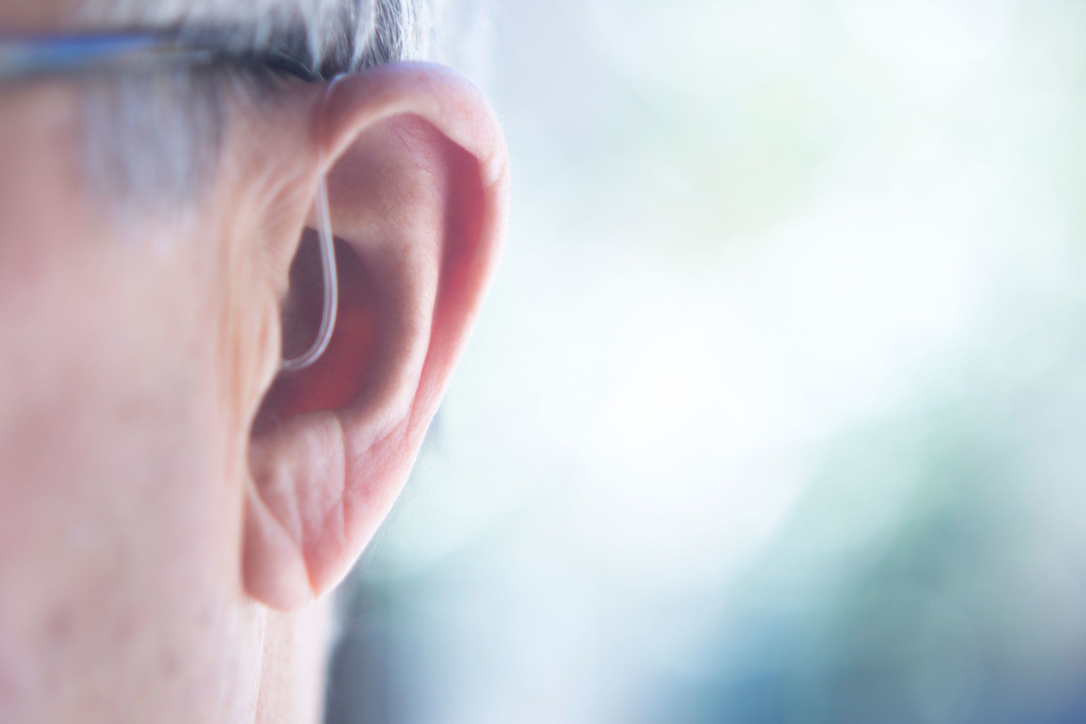 An image of an older person wearing a hearing aid.