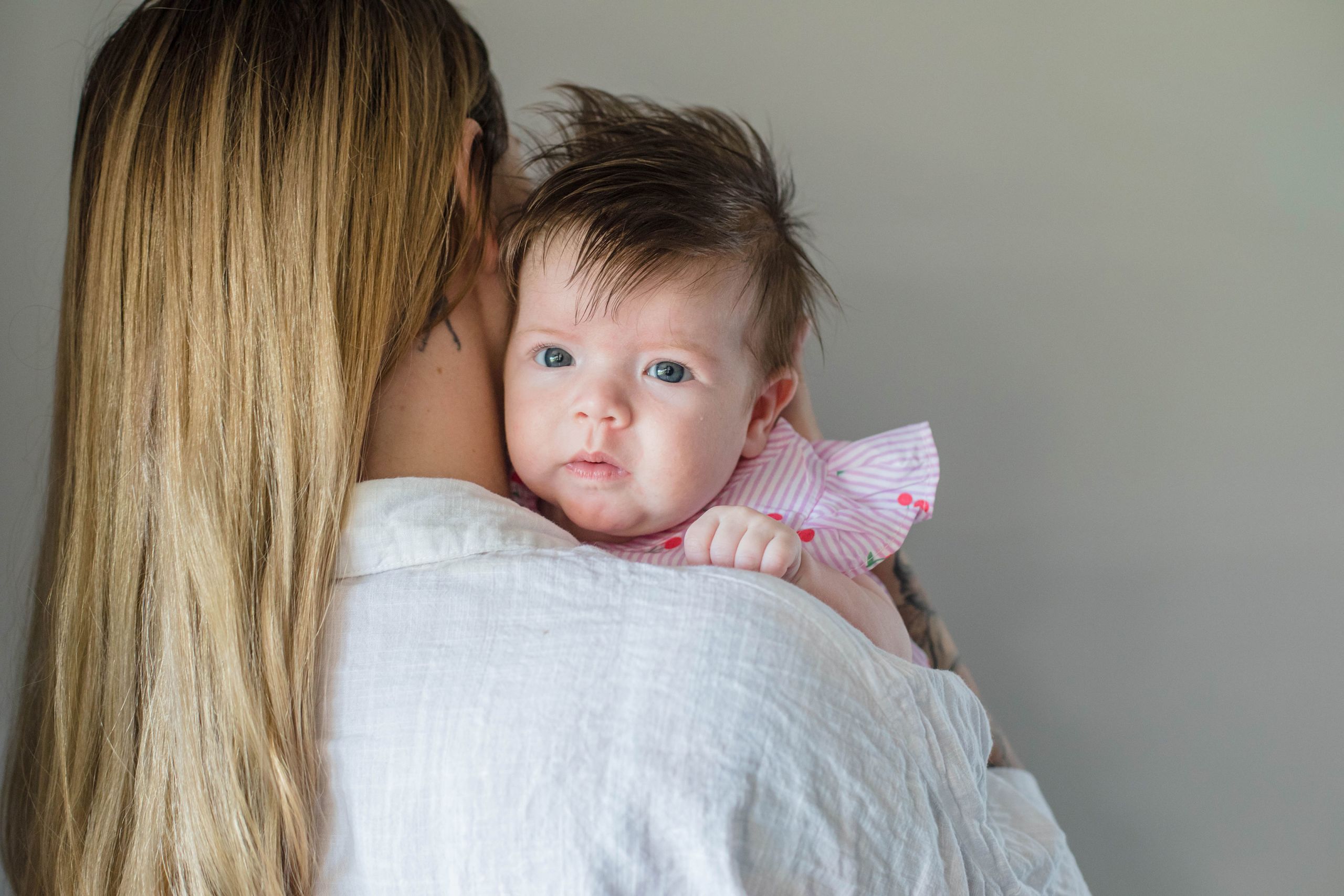 An image of baby June looking over the shoulder of her mother Jasmine Cameron.