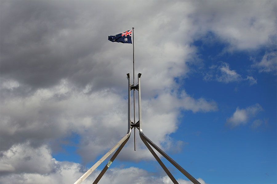 An image of the flag flying over Australian Parliament House.