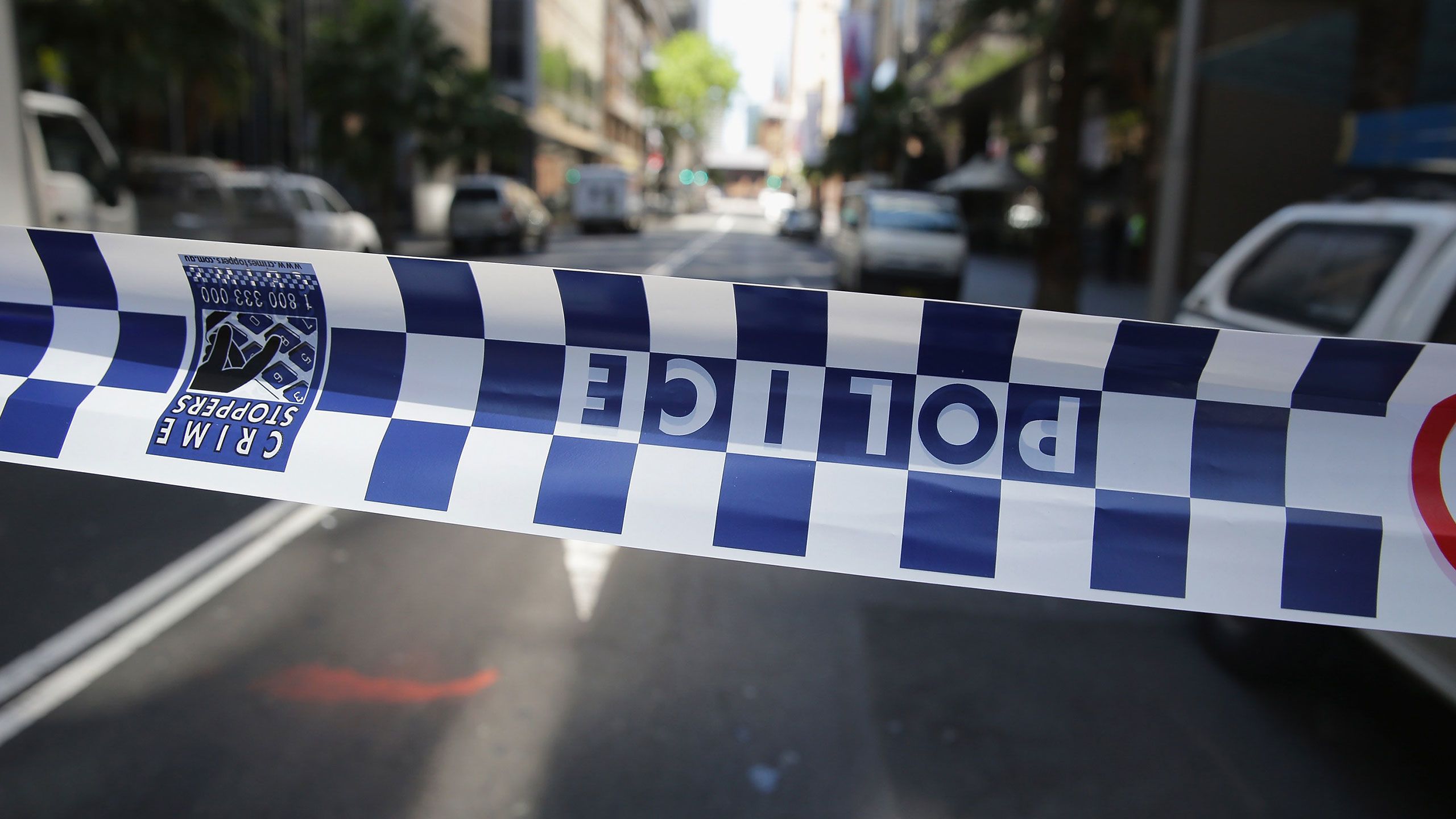 An image of of police tape blocking a road.