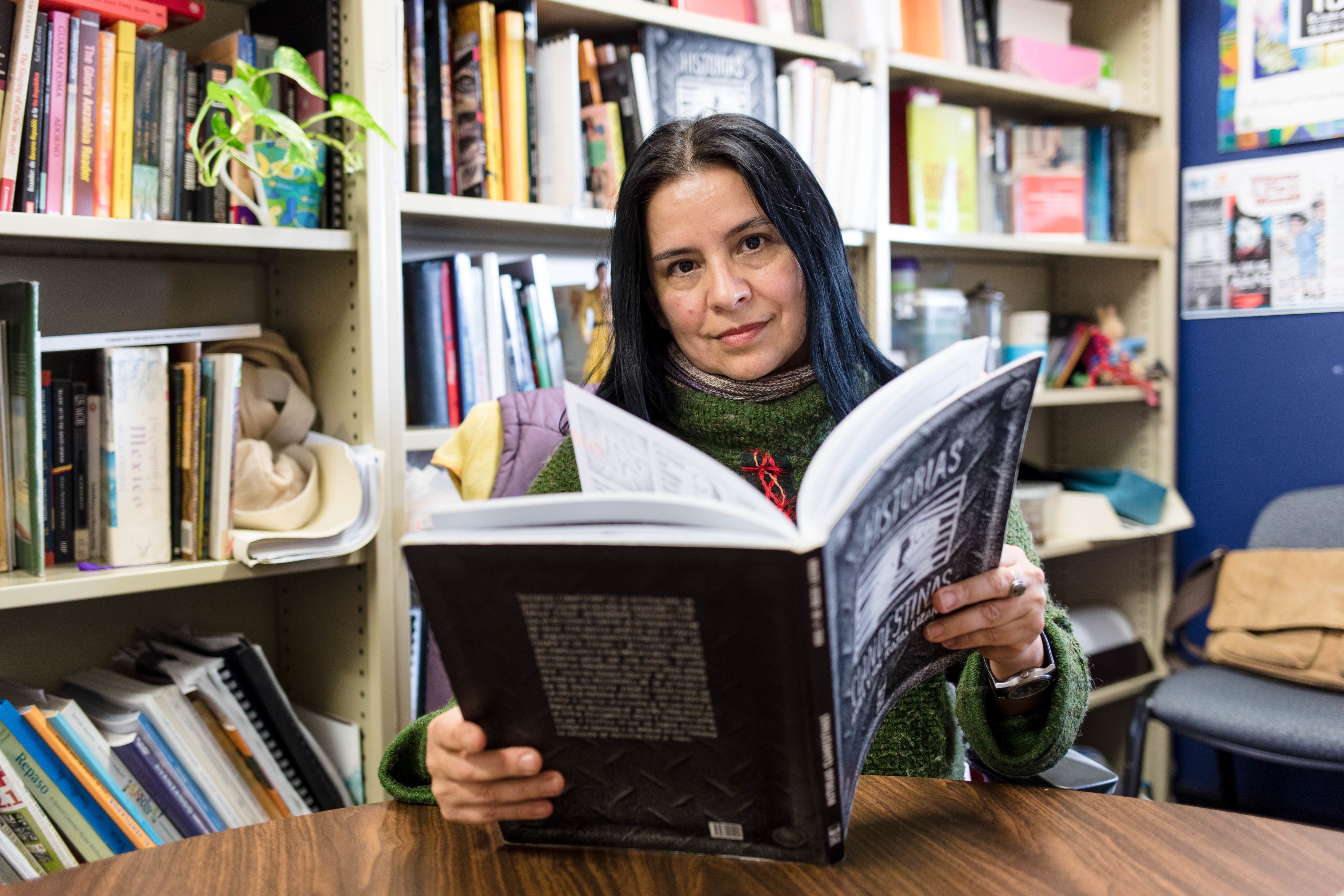 An image of Dr Sol Rojas-Lizana reading the graphic novel Historias Clandestinas, which she co-authored with her brother Ariel Rojas-Lizana.
