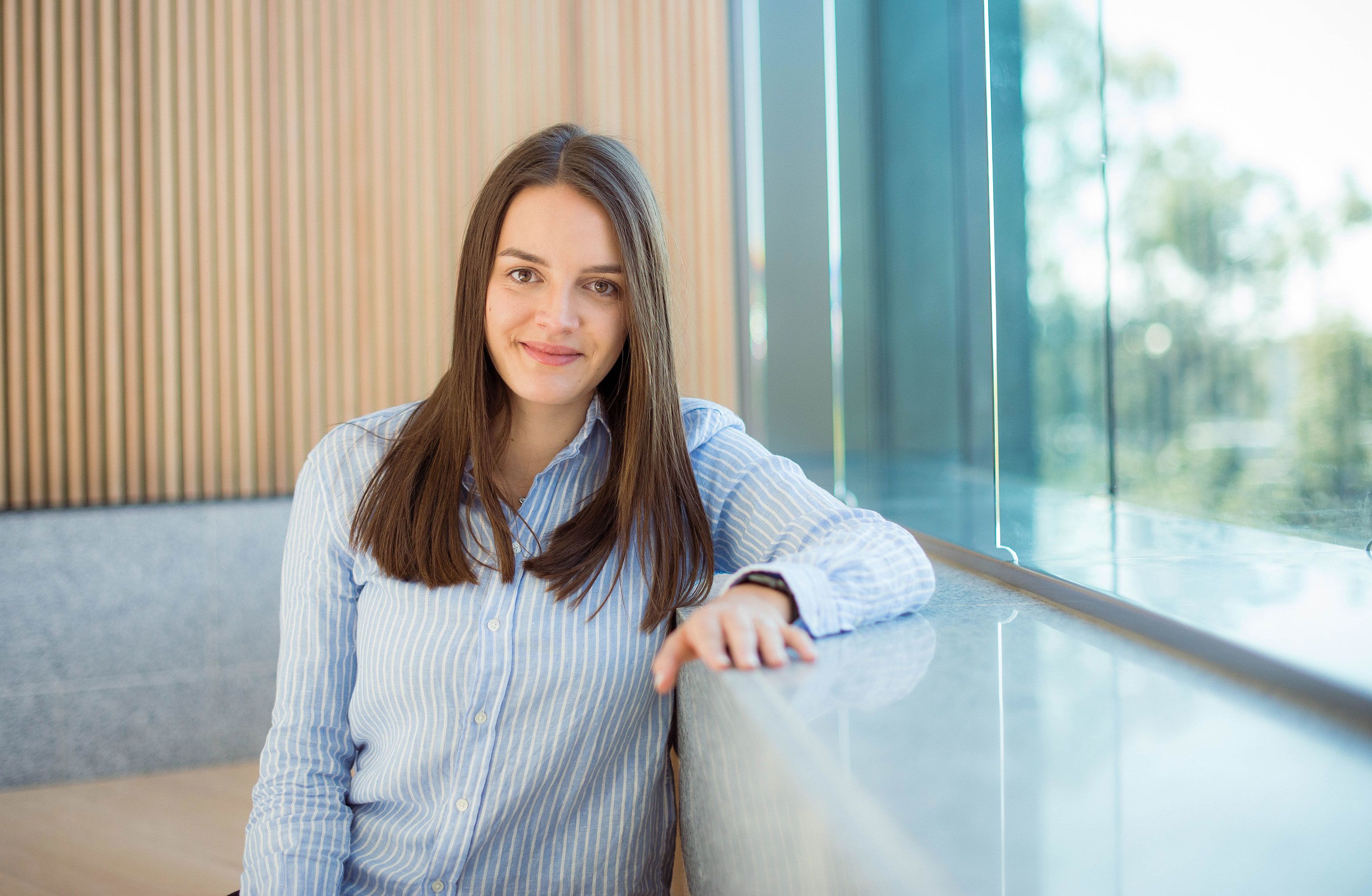 Lara Harbers sitting in the foyer of the Sir Llew Edwards building