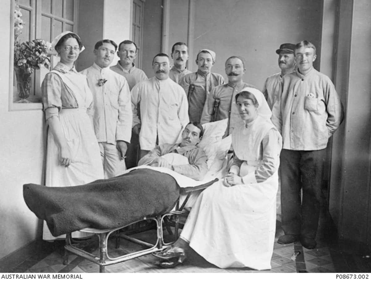Black and white image of nurses and patient at the Auxiliary Hospital Unit in Belgium.
