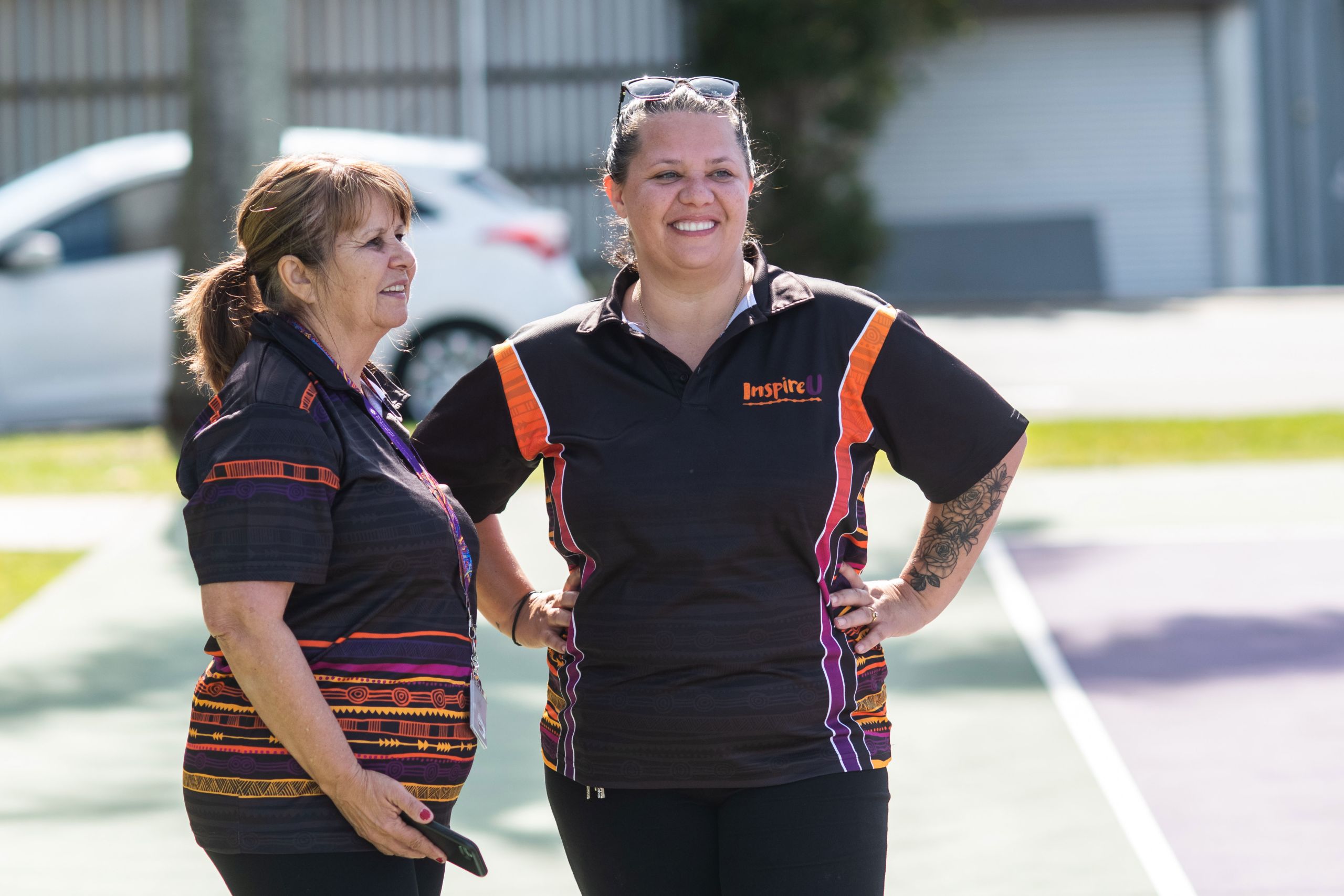 An image of UQ Aboriginal and Torres Strait Islander Studies Unit staff members Robyn Donnelly and Emma Olssen watch the game between Diamond Spirit camp participants and UQ’s Goorie Berrimpa Student Collective.