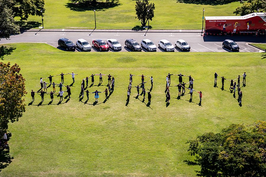 An image of UQ staff and students spell out 'Sorry' at the St Lucia campus, showing their support for families impacted by the Stolen Generations.