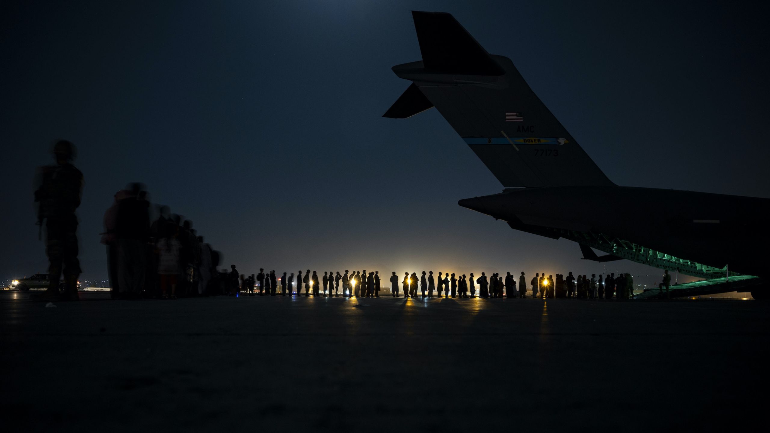 An air crew prepares to load evacuees aboard a C-17 Globemaster III aircraft at Hamid Karzai International Airport