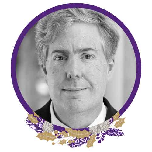 Black and white image of Professor Alastair Blanshard. The image has a purple circular border with a purple and gold native wreath at the bottom.