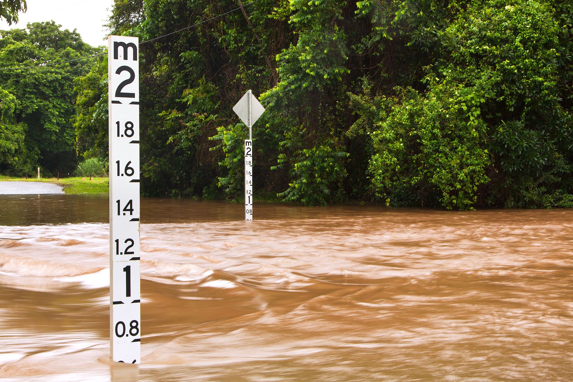 Flooded road with depth indicators in Queensland, Australia. Image: Johan Larson / Adobe Stock.