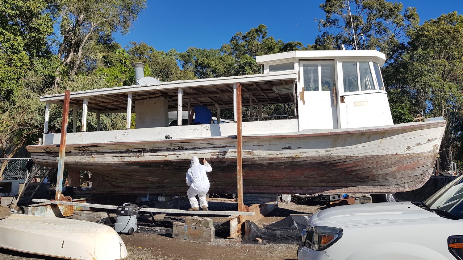 UQ Property and Facilities staff inspect the exterior of the run down ferry.