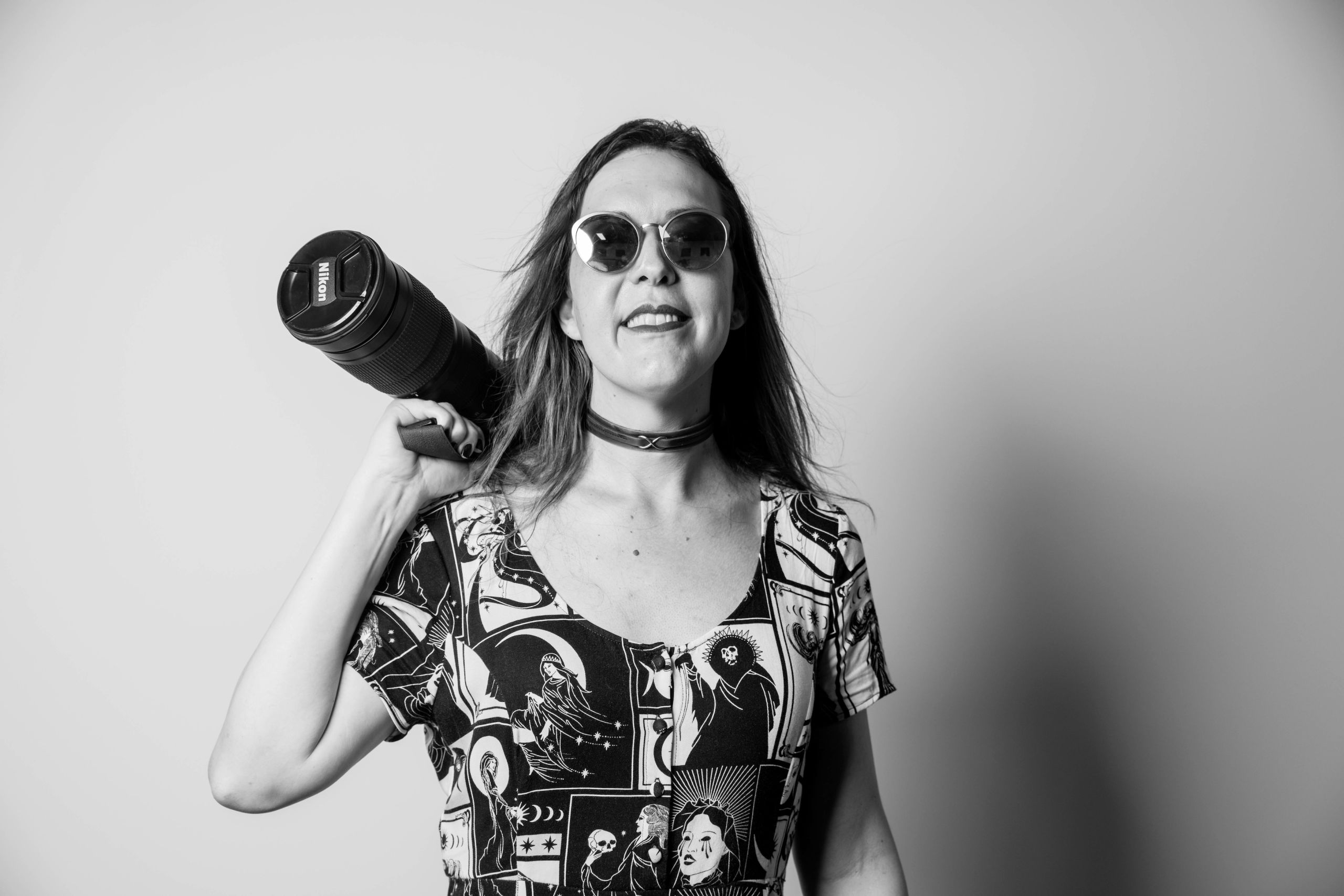 Chelsea Morrigan poses with her camera in a black and white photograph.