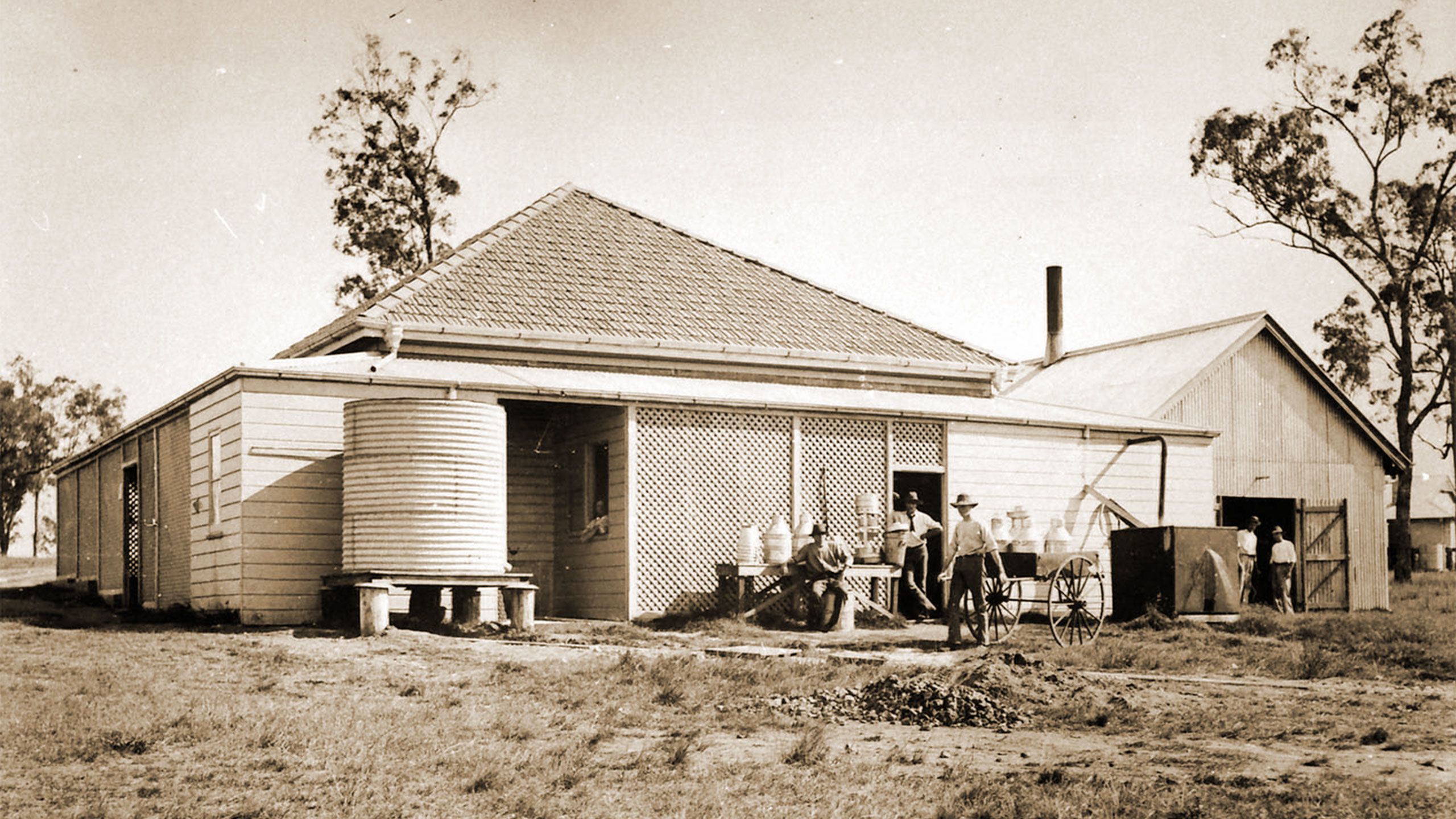 An image of workers gathering produce from the butter factory at the Gatton campus in 1902.