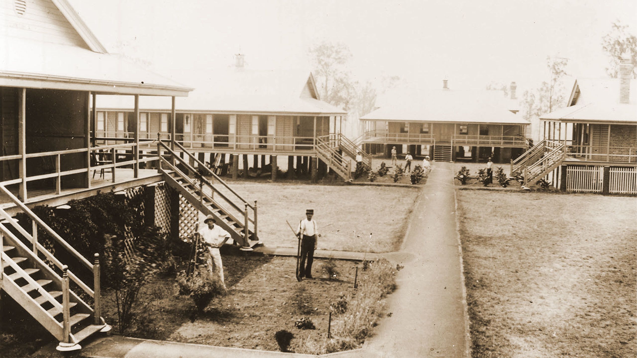 Men working the gardens outside the student dormitories and dining hall in 1898.