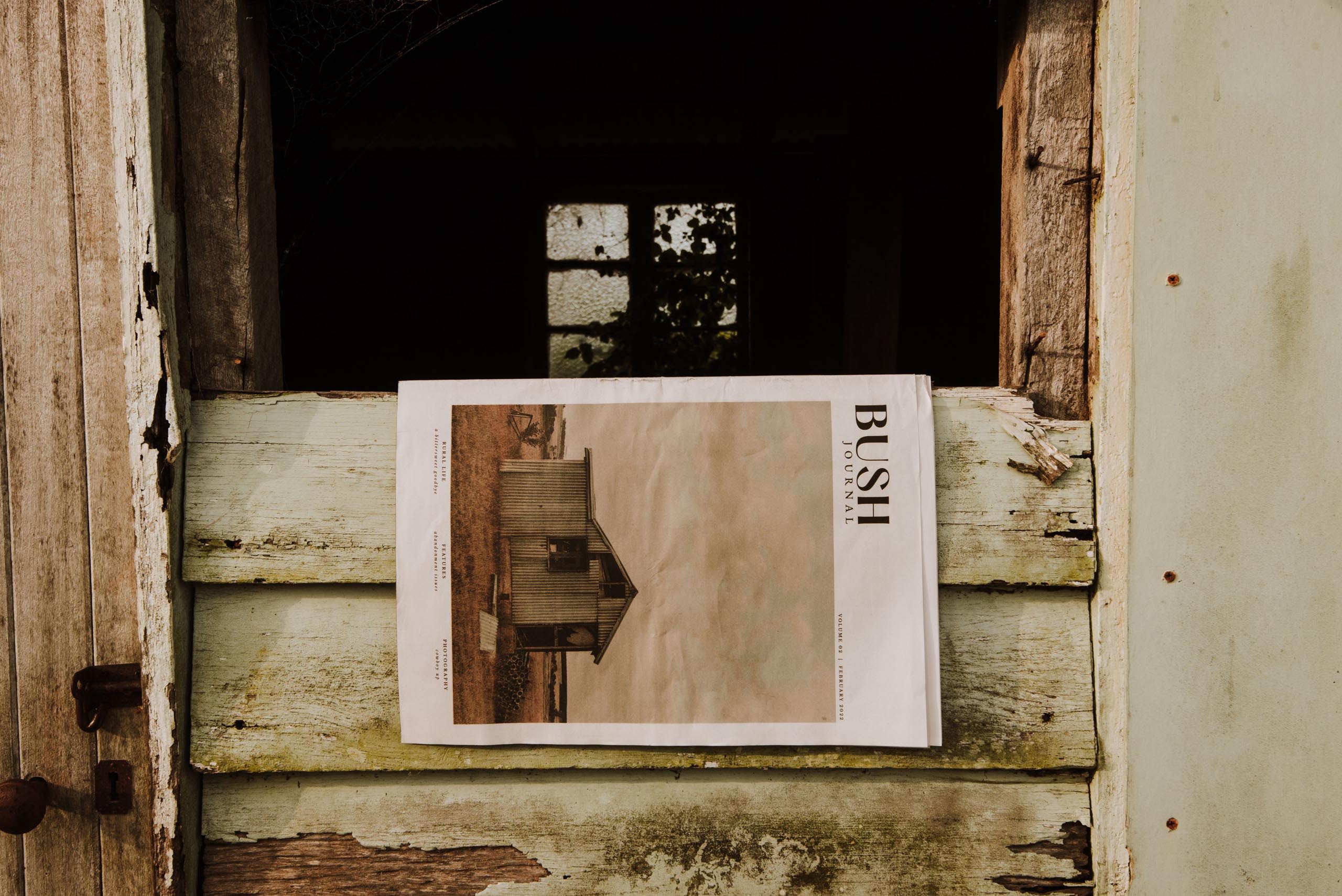 A copy of the Bush Journal hangs on a door of an old shed.