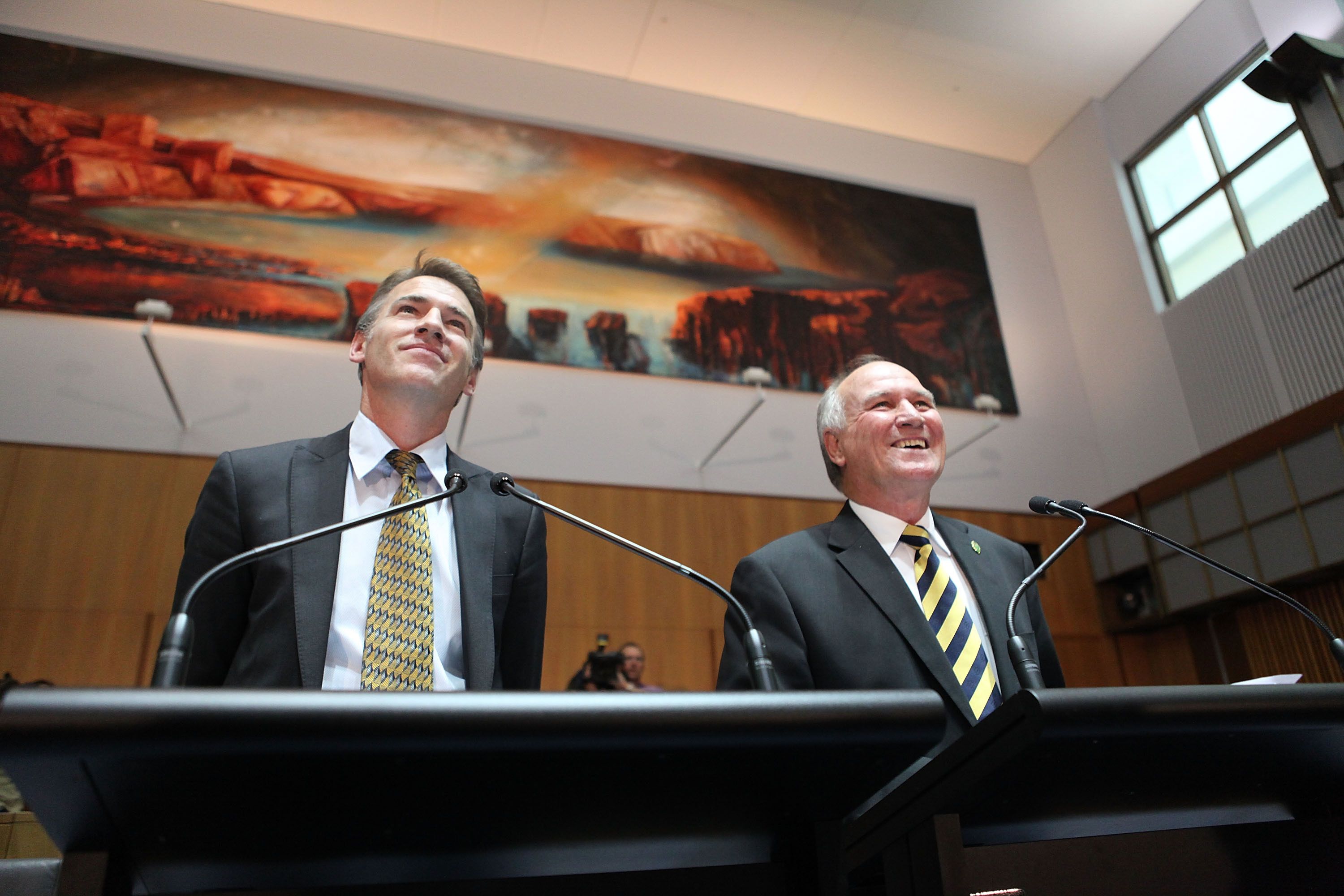 Rob Oakeshott and Tony Windsor smiling as they stand on a podium