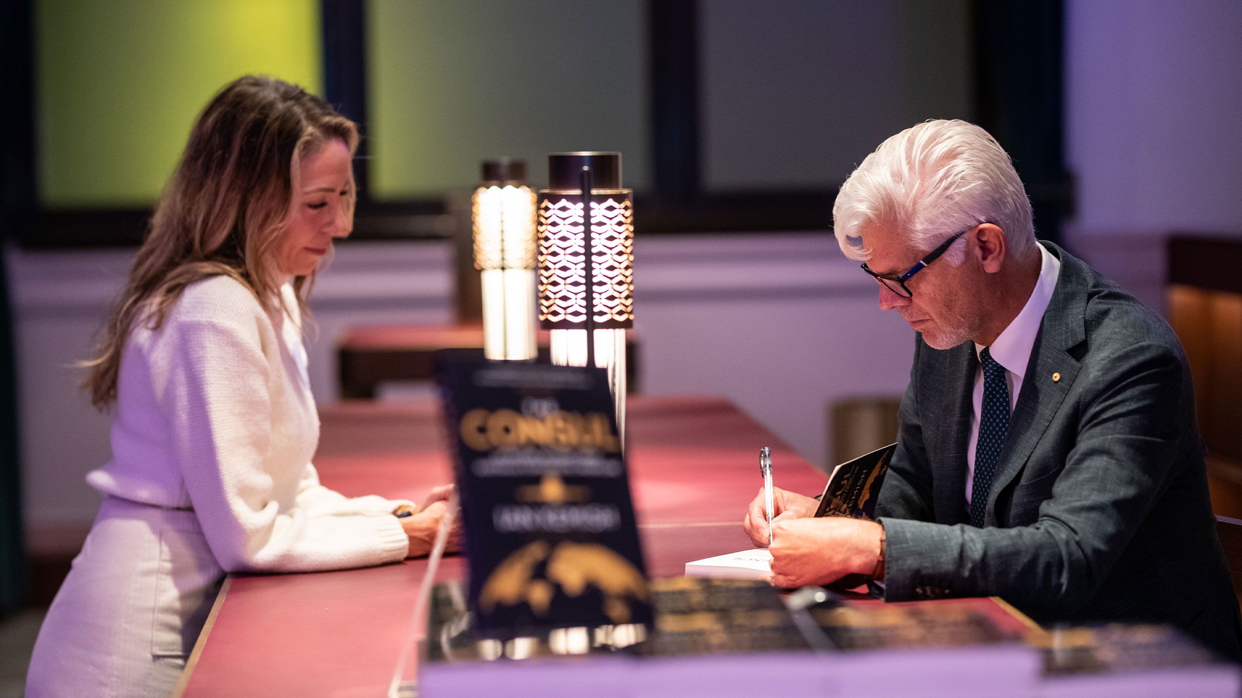 An image of Ian Kemish signs a copy of The Consul at the book's launch at UQ Brisbane City in July.