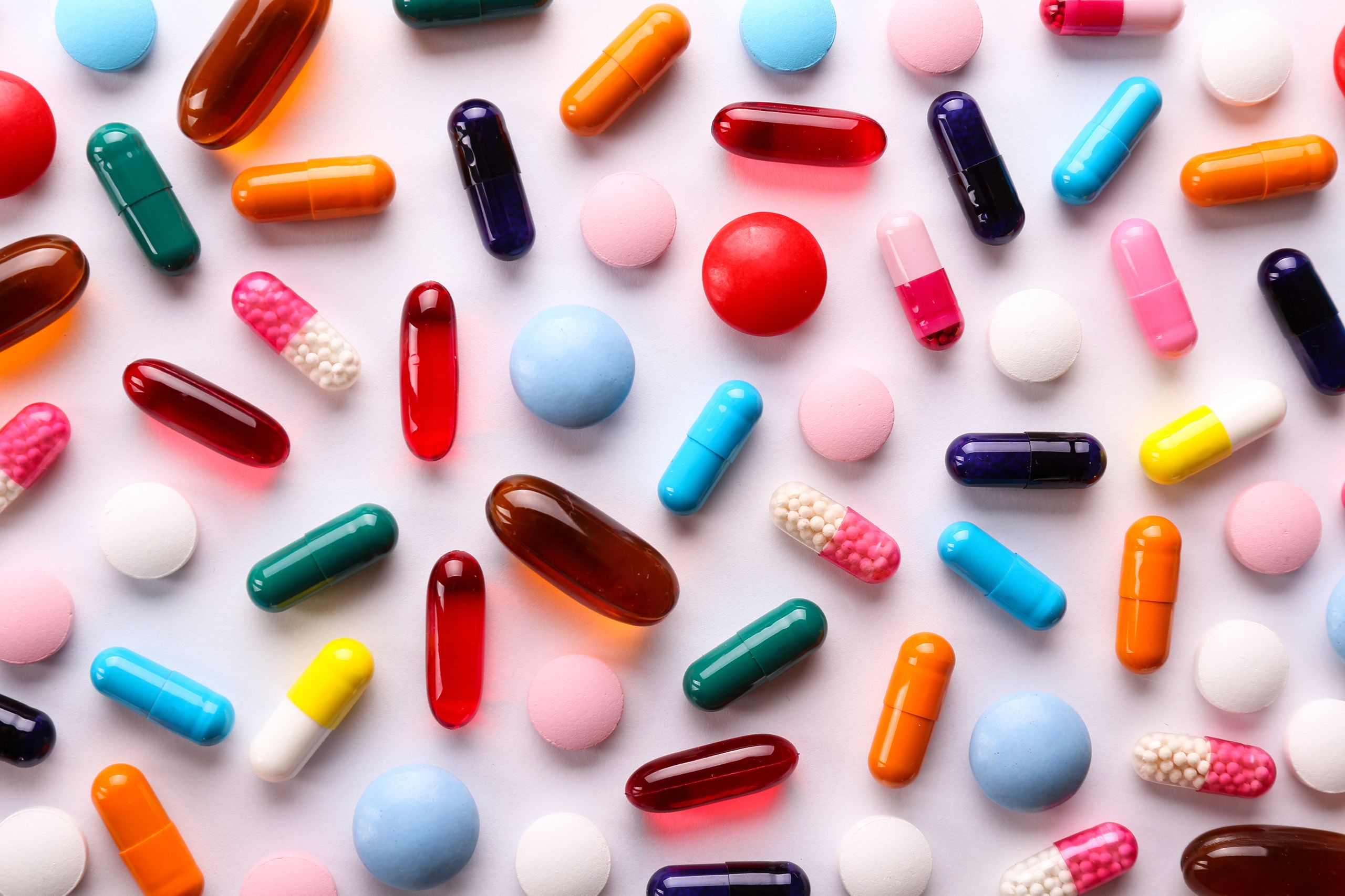 Many vitamin tablets laying on a table