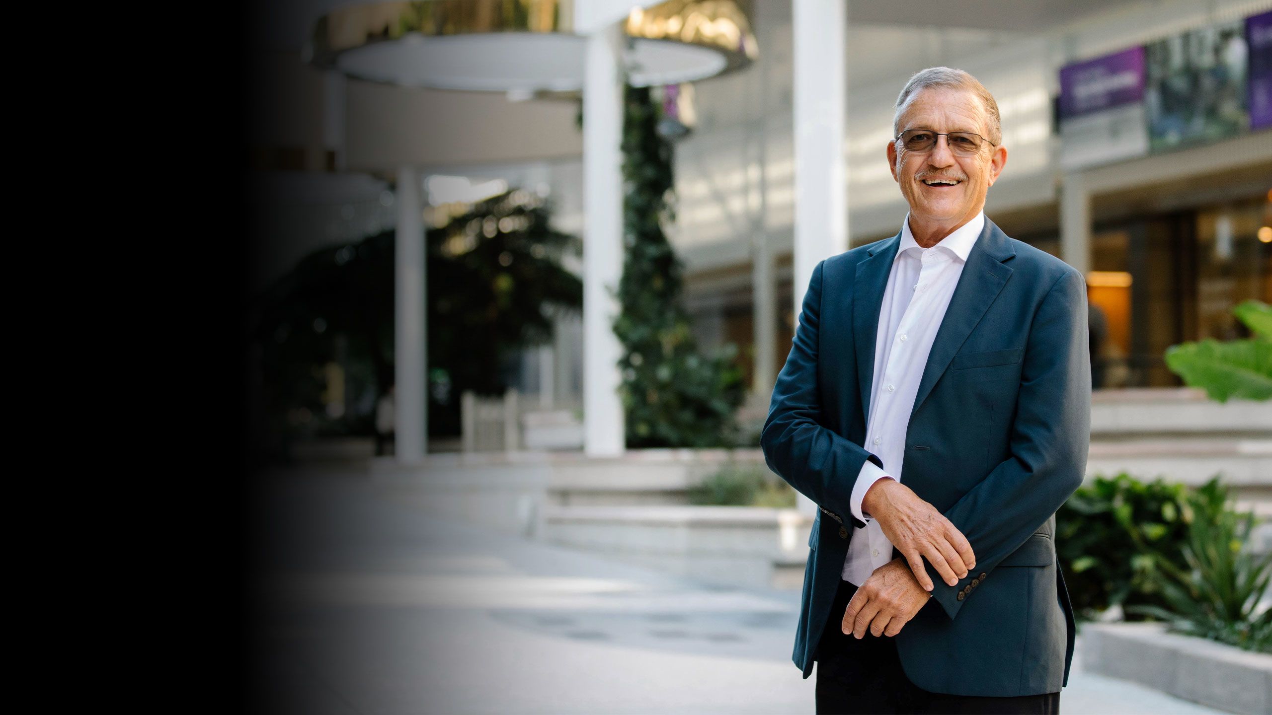 Bob Christiansen standing in front of a building smiling.
