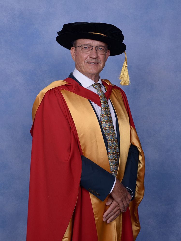 Bob Christiansen portrait shot with honorary doctoral robe and bonnet.