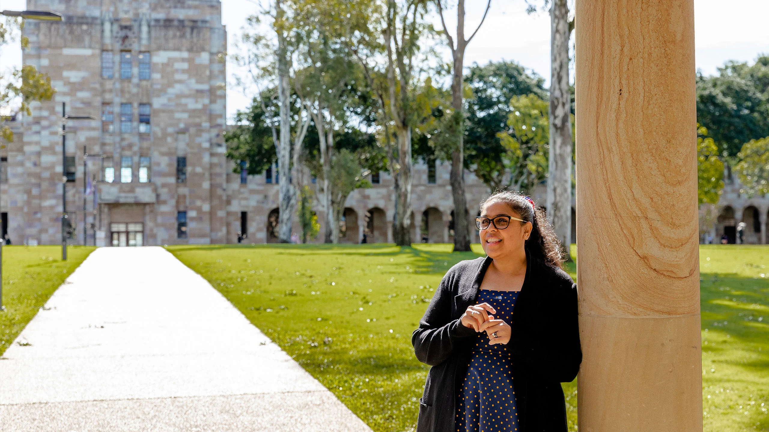 An image of Journalist and UQ alum Rhianna Patrick with UQ's Great Court in the background.