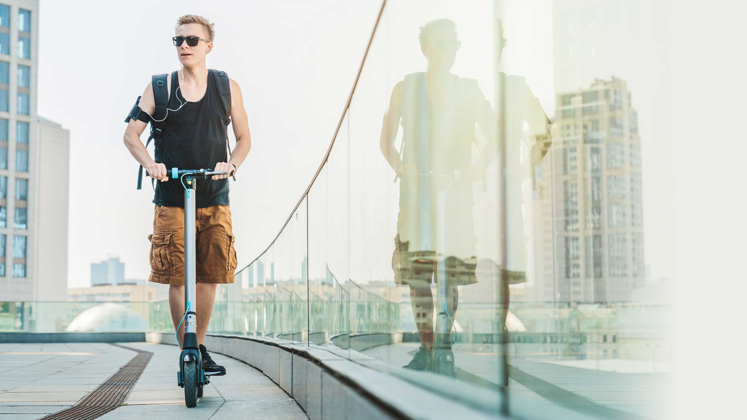 An image of a man riding an e-scooter through a city.
