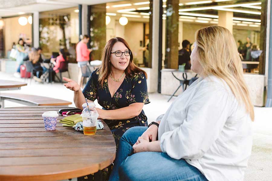 An image of Dr Thea Voogt and Alison Pike chatting over coffee at UQ's St Lucia campus.