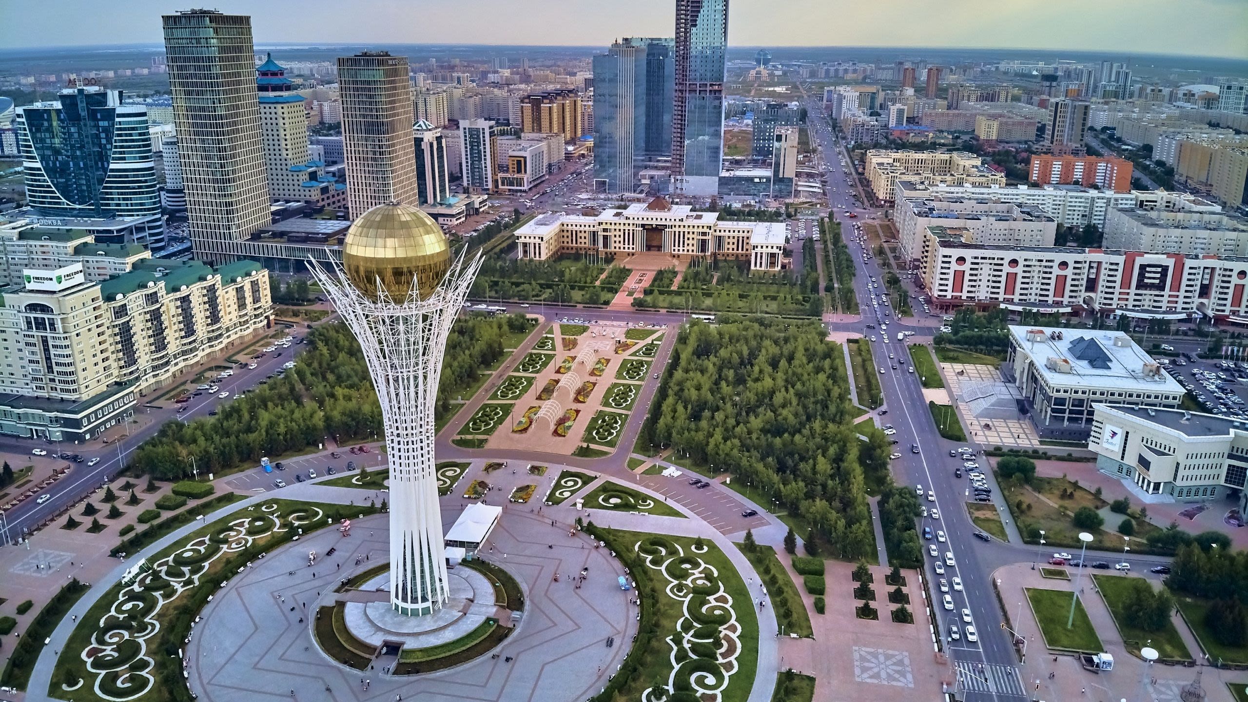 A tower with a gold sphere on top, surrounded by other skyscrapers in the distance.