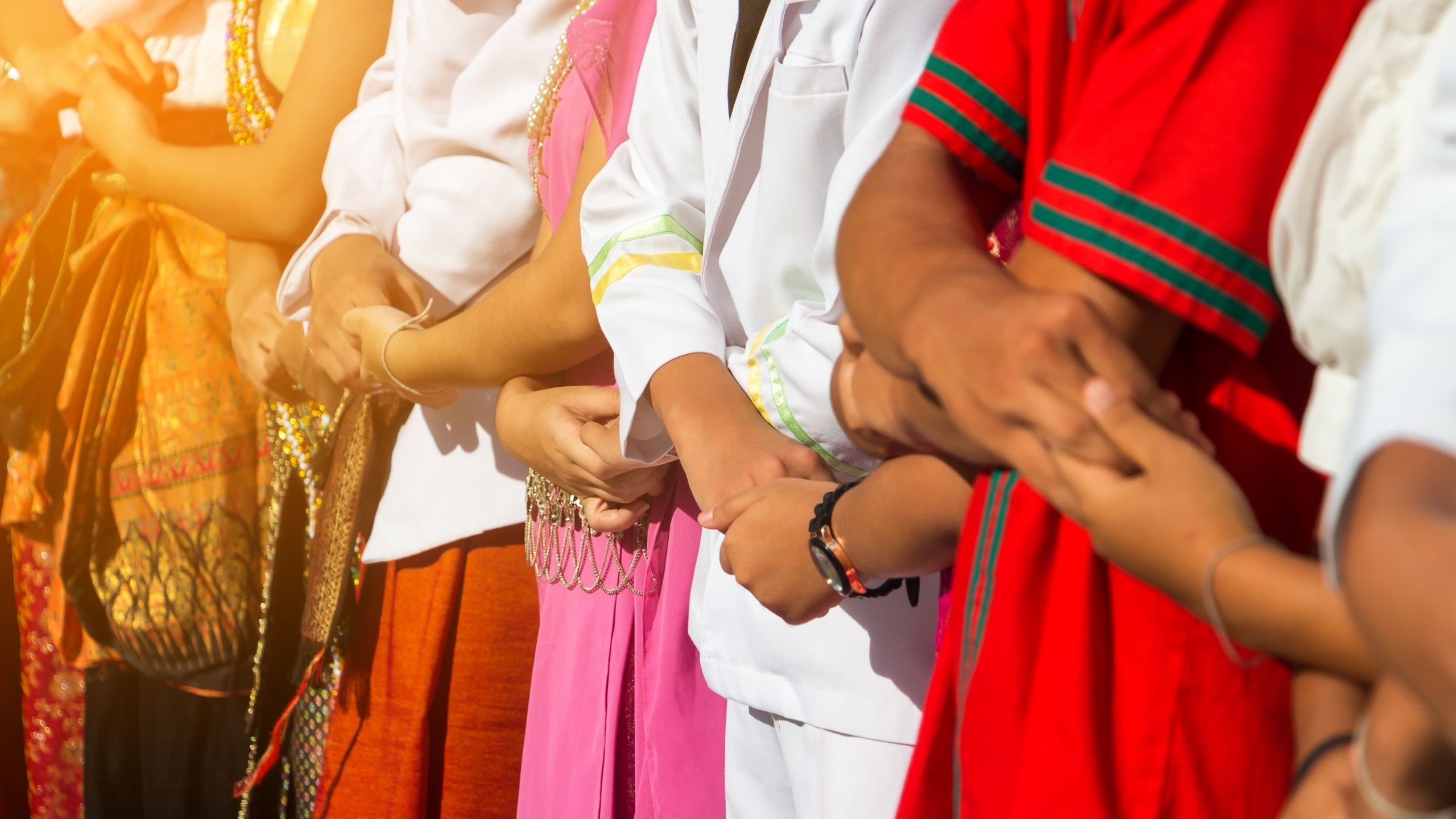 People standing in a line with their arms interlinked.