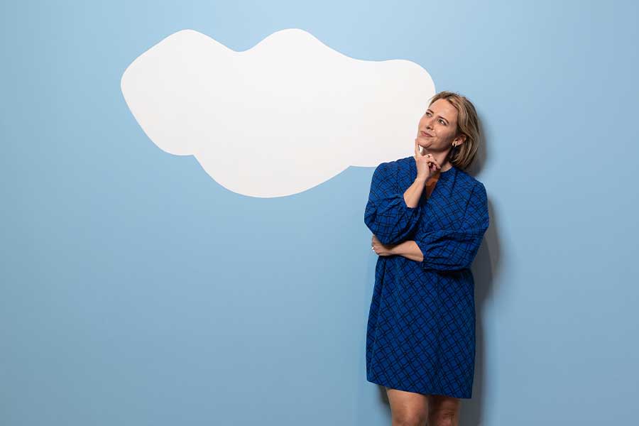 An image of Children’s Gallery Coordinator Jodi Ferrari posing in front of a colourful wall space inside the Children's Gallery at HOTA.