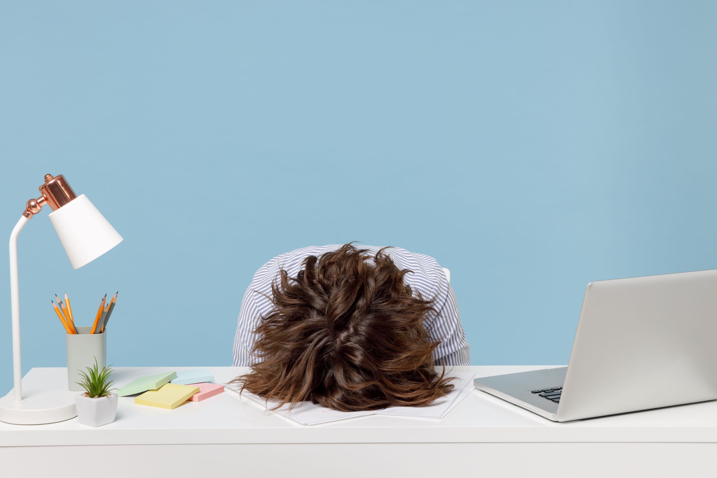 A woman with her head on a desk